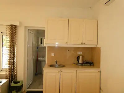 a kitchen with white cabinets and a sink at Apartments In Amor in Ulcinj
