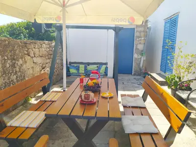 a picnic table with a bowl of fruit on it at Holiday House Stari Volat in Budva