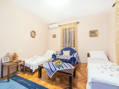 a living room with two beds and a table at Holiday House Stari Volat in Budva