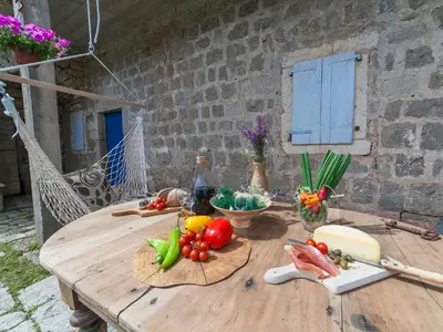 a wooden table with fruits and vegetables on it at Holiday House Stari Volat in Budva