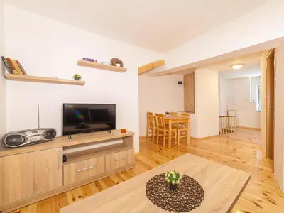 a living room with a television and a table at Apartments Kaleta in Kotor