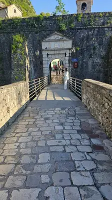 a woman walking across a bridge in a castle at Apartments Kaleta in Kotor