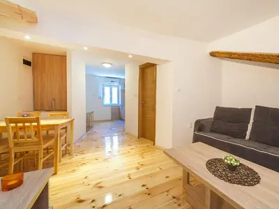 a living room and kitchen with a couch and a table at Apartments Kaleta in Kotor