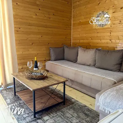 a living room with a couch and a table with wine glasses at Apartmani Konoba Starčevo in Virpazar