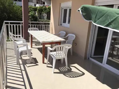 a patio with a table and chairs on a balcony at Vip Apartmani Canj in Čanj