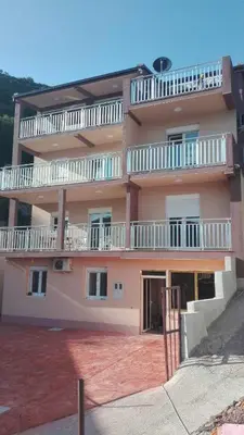 a large pink building with balconies on top of it at Vip Apartmani Canj in Čanj