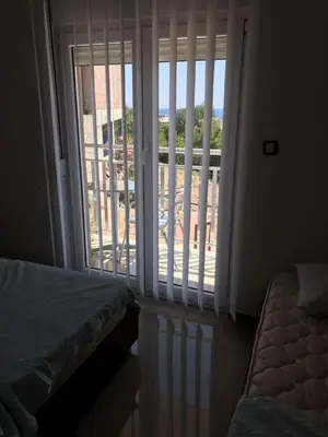 a bedroom with a sliding glass door with a balcony at Vip Apartmani Canj in Čanj