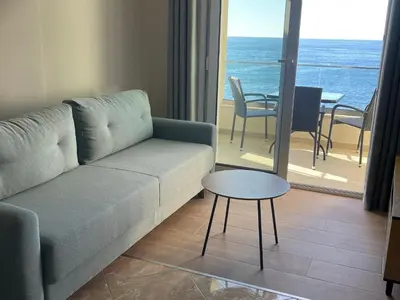 a living room with a couch and a table at Apartments Posejdon in Utjeha