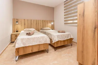 a bedroom with two beds and a window at Apartments Posejdon in Utjeha