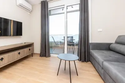 a living room with a couch and a table at Apartments Posejdon in Utjeha