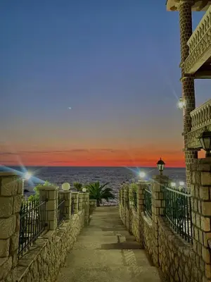 a pathway leading to the beach at sunset at Apartments Posejdon in Utjeha