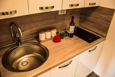a kitchen counter with a sink and a bottle of wine at Apartmani Mendula in Budva