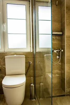 a bathroom with a toilet and a glass shower at Apartmani Mendula in Budva