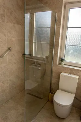 a bathroom with a toilet and a glass shower at Apartmani Mendula in Budva