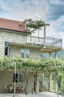 a house with a deck on top of it at Apartmani Mendula in Budva