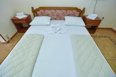 a bedroom with a bed with two nightstands and a bed sidx sidx sidx at Hotel Grbalj in Budva