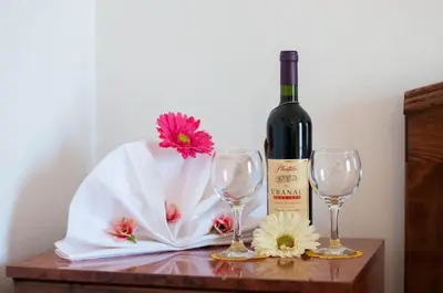 a bottle of wine and two wine glasses on a table at Hotel Grbalj in Budva