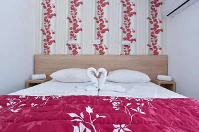a bed with two white towels in the shape of hearts at Hotel Grbalj in Budva