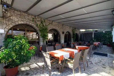 a patio with a table and chairs and a building at Hotel Grbalj in Budva