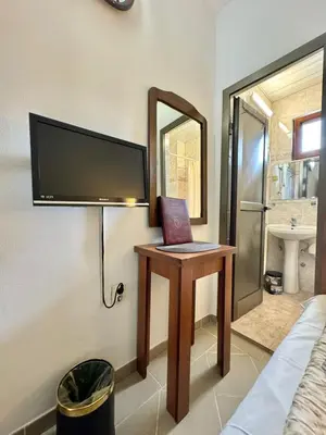 a room with a desk with a tv and a mirror at Hotel Grbalj in Budva
