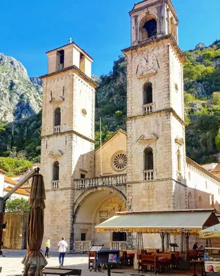 a large building with two towers with a clock on it at Old town Kotor Square in Kotor