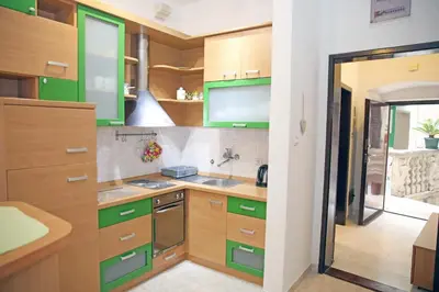 a kitchen with green cabinets and a sink at Old town Kotor Square in Kotor