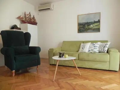 a living room with a green couch and a chair at Apartments Captain's Villa in Budva