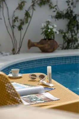 a table with a cup and glasses next to a pool at Apartments Captain's Villa in Budva