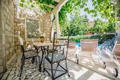 a patio with a table and chairs and a pool at Apartments Captain's Villa in Budva