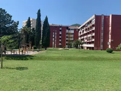 a park in front of a building with a playground at Apartment Oleander in Budva