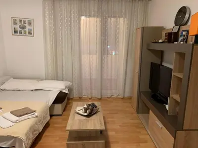 a room with two beds and a tv and a table at Apartment Oleander in Budva