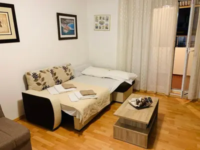 a small room with a bed and a table at Apartment Oleander in Budva