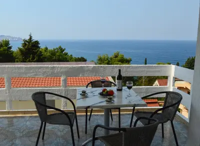 a table with a bottle of wine and fruit on a balcony at Apartment Sunny in Bar