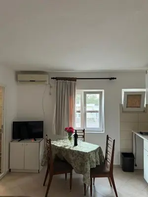 a kitchen with a table with a vase of flowers on it at Apartmani Dada in Kotor