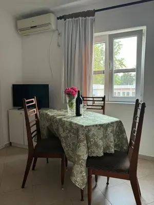 a dining room table with a vase of flowers on it at Apartmani Dada in Kotor