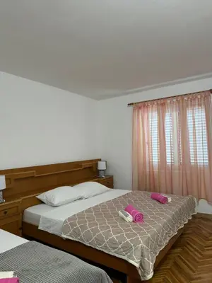 a bedroom with two beds with pink pillows on it at Apartmani Dada in Kotor