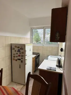 a kitchen with a white refrigerator and a table at Apartmani Dada in Kotor