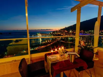 a table on a balcony with a view of a city at Luxury Apartments Tre Canne Can in Budva