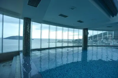 a swimming pool in a building with a view of the ocean at Luxury Apartments Tre Canne Can in Budva