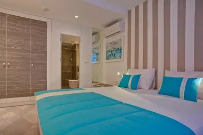 a bedroom with a large bed with blue and white pillows at Hotel Aleksandar in Budva