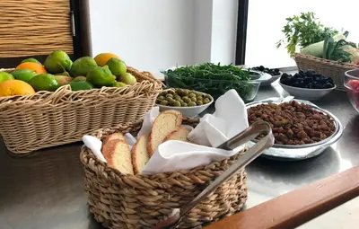 a table with baskets of bread and other fruits and vegetables at Hotel Aleksandar in Budva