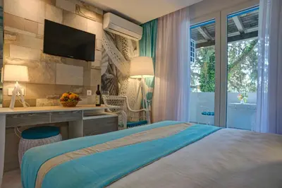 a bedroom with a bed and a desk and a television at Hotel Aleksandar in Budva