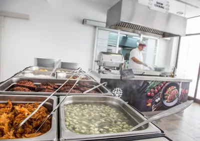 a chef preparing food in a restaurant kitchen at Hotel Aleksandar in Budva