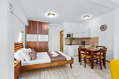 a bedroom with a bed and a table and a kitchen at Apartments Casa Mia in Kotor
