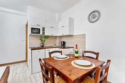 a kitchen with a wooden table and chairs in a room at Apartments Casa Mia in Kotor