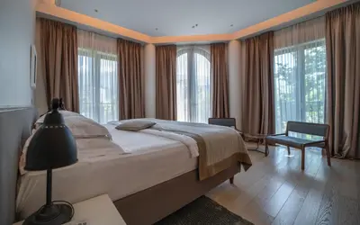a bedroom with a large bed and windows at Hotel Majestic in Budva