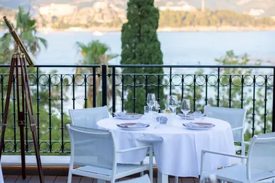 a white table and chairs with a view of the water at Hotel Majestic in Budva