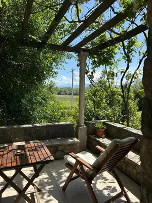 a patio with a table and a chair and a table at Lake house Puro in Dodoši