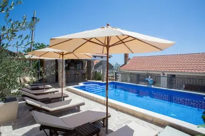a group of chairs and an umbrella next to a swimming pool at Holiday home Kristina in Krimovice