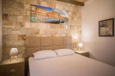 a bedroom with a bed with two lamps and a stone wall at Holiday home Kristina in Krimovice